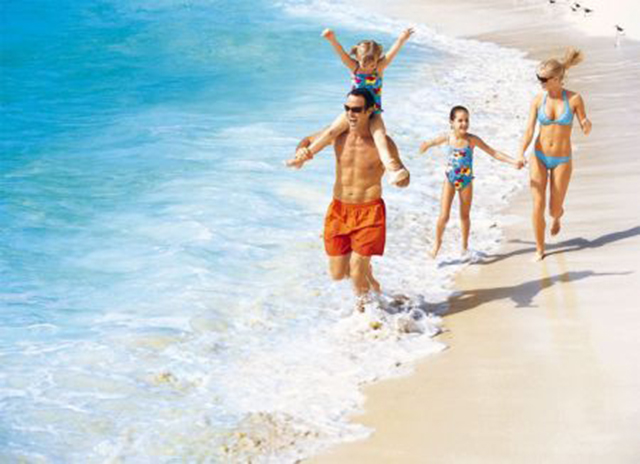 Famiglia felice in vacanza al mare con bambini e nuovo partner