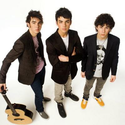 I Jonas Brothers sorridenti e vestiti con stile durante un evento musicale