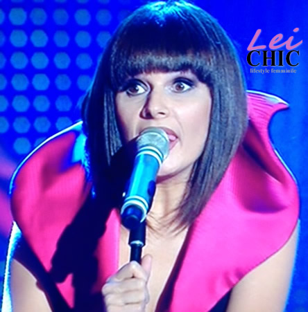 Silvia Mezzanotte durante la performance dei Matia Bazar a Sanremo, indossa un elegante abito nero con colletto rosso e accessori minimalisti