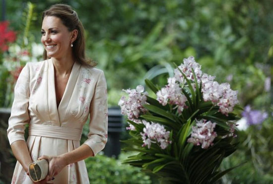 Kate Middleton sorridente in abito elegante durante un evento ufficiale