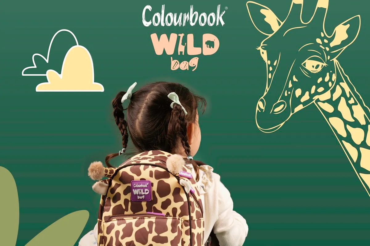 Bambina di spalle con zaino a tema giraffa Colourbook Wild Bag davanti a un'illustrazione di giraffa su sfondo verde