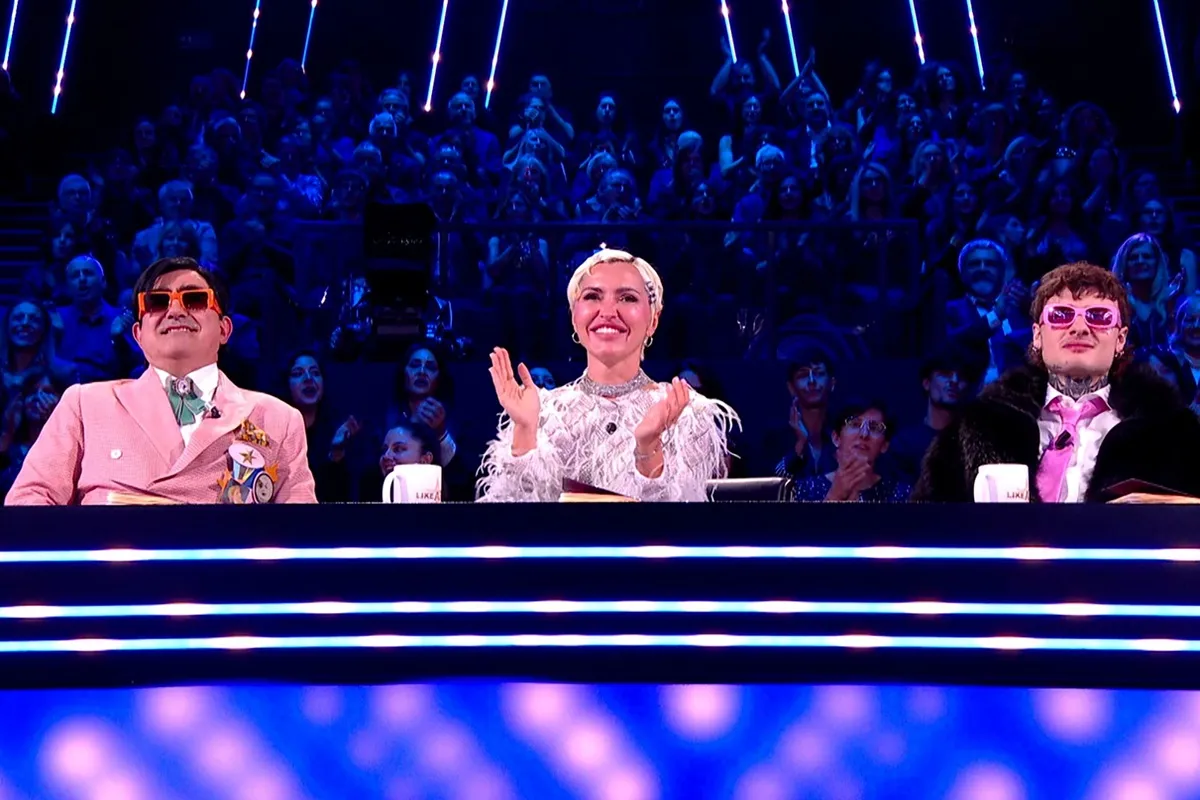 I giudici Elio, Rosa Chemical e Serena Brancale nel programma Like a Star, assistendo alle performance dei concorrenti con abiti colorati e uno stile moderno. L'immagine mostra il trio di giudici mentre applaudono, con il palco illuminato sullo sfondo.