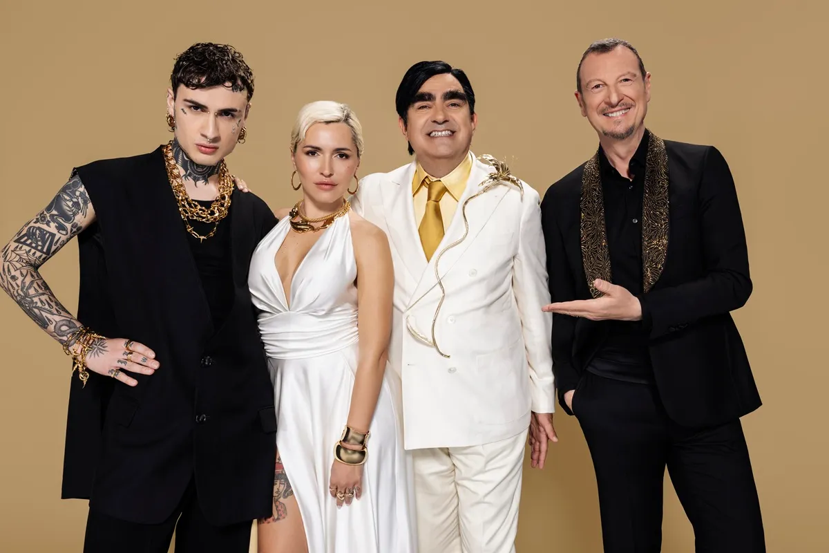 I giudici di Like a Star: Rosa Chemical, Serena Brancale, Elio e il conduttore Amadeus posano insieme in abiti eleganti su sfondo beige.