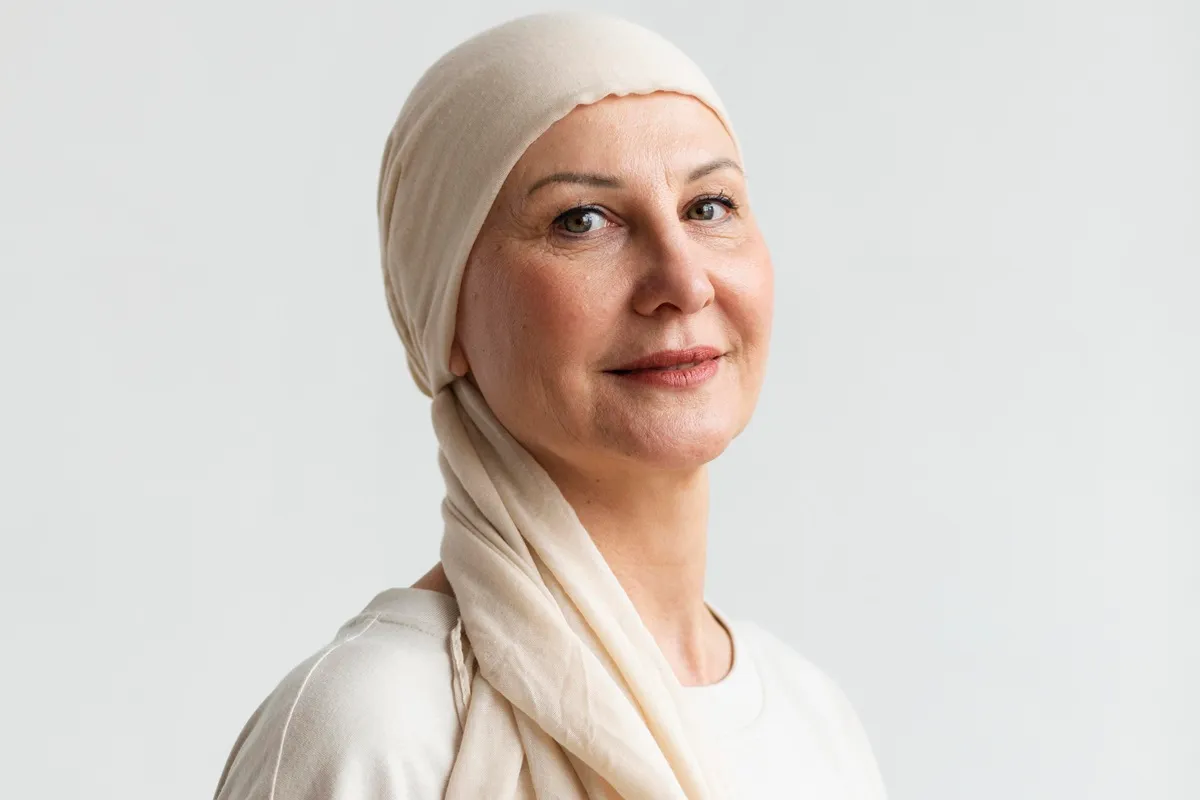 Ritratto di una donna di mezza età con turbante, sorridente, che riflette forza e serenità