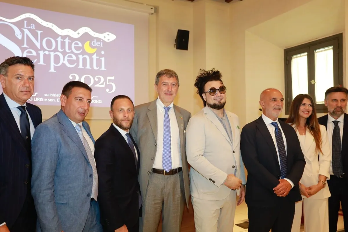 Gruppo di autorità e il maestro Enrico Melozzi posano davanti allo schermo con logo La Notte dei Serpenti 2025