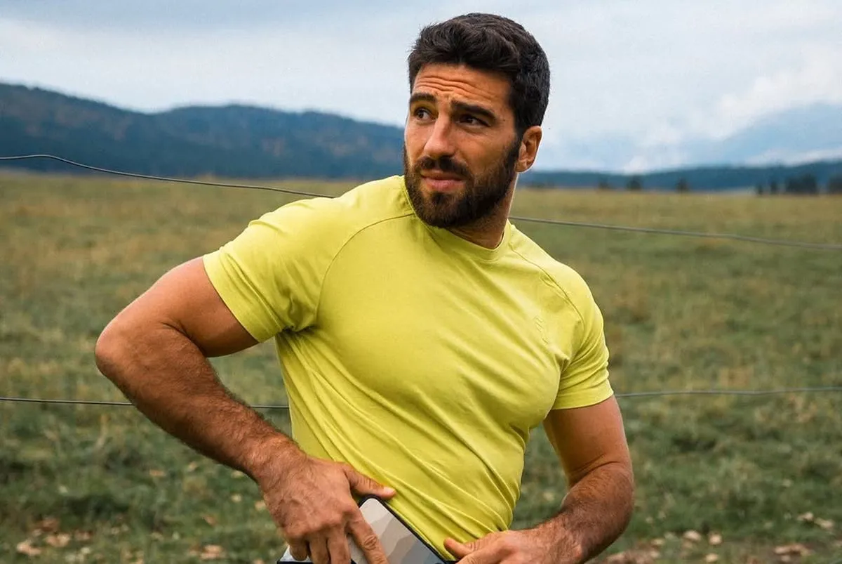 Alvise Rigo con maglietta sportiva gialla all’aperto, modello e atleta italiano legato sentimentalmente a Elisabetta Canalis