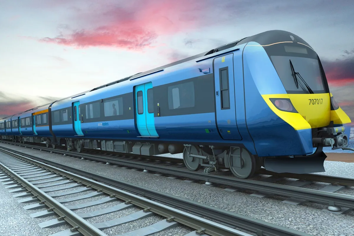 Treno passeggeri blu di Southeastern Railways che corre sui binari al tramonto, con design aerodinamico e porte azzurre