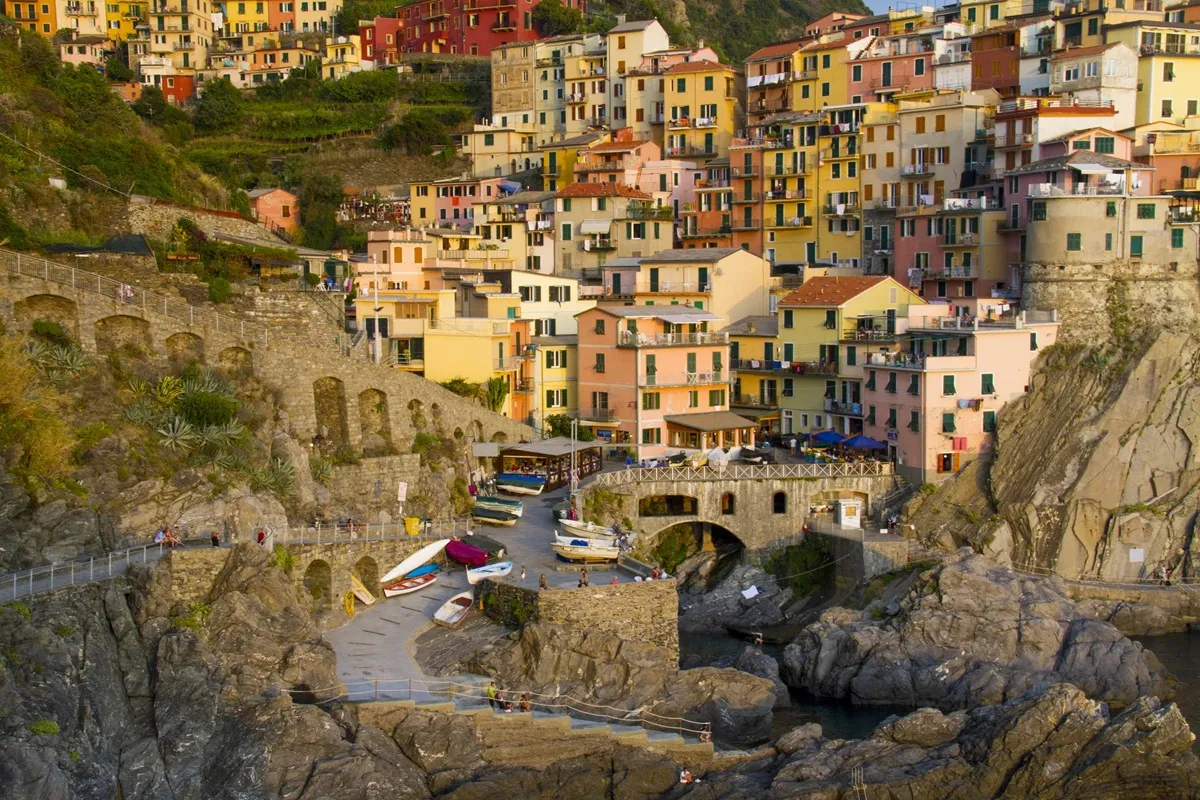 Veduta panoramica di Manarola nelle Cinque Terre con case colorate arroccate sulla scogliera e piccola marina