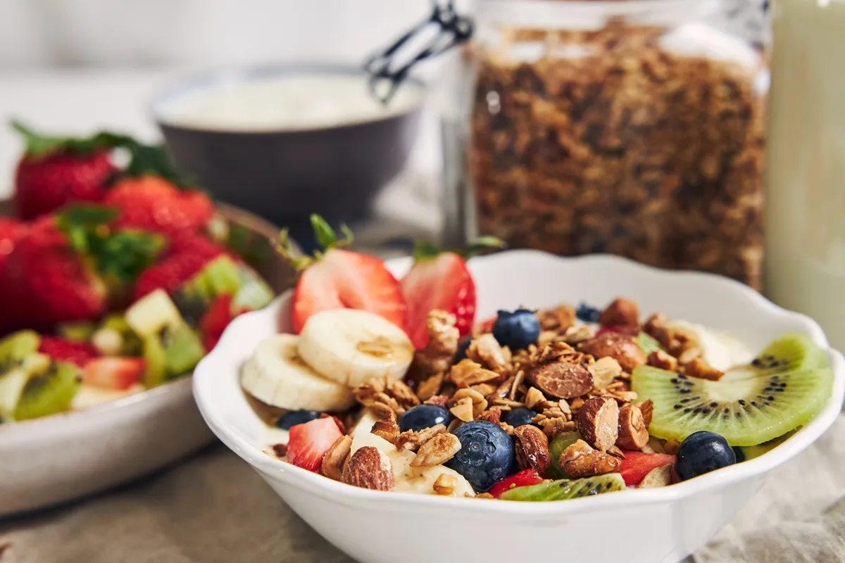 Ciotola con yogurt, fragole, banane, mirtilli, kiwi e granola: colazione sana e veloce