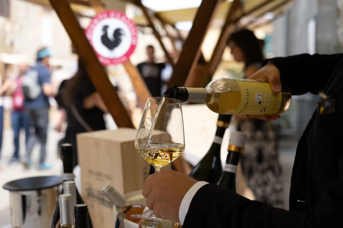 Un calice di vino bianco viene versato durante una degustazione al festival Sorsi di Vagliagli, nel cuore del Chianti Classico.