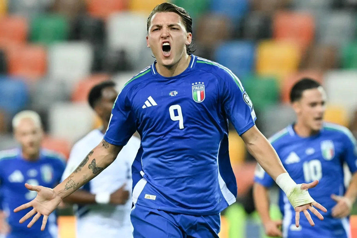 Calciatore della Nazionale Italiana esulta dopo un gol, indossando la maglia azzurra numero 9, con espressione grintosa e braccia aperte in segno di vittoria.