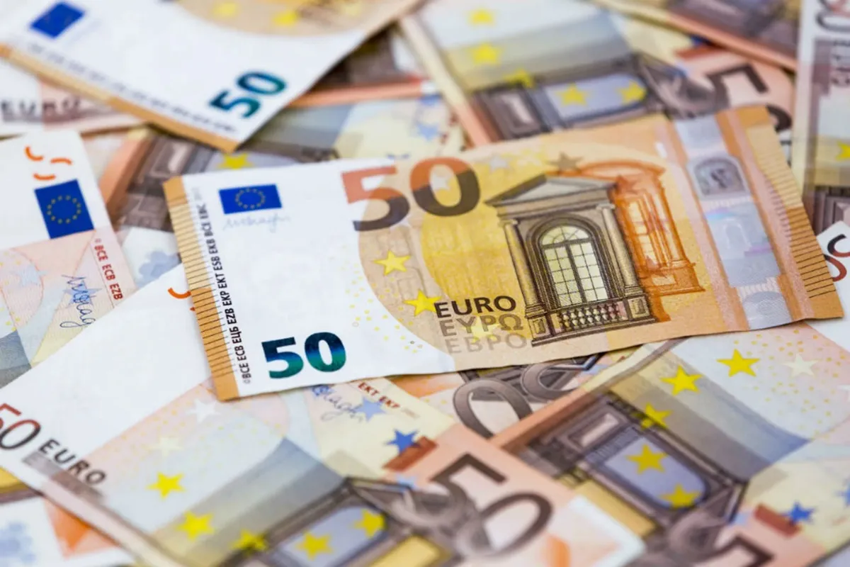 Diverse banconote da 50 euro sovrapposte, mostrando dettagli di colori, simboli e sicurezza della valuta europea.