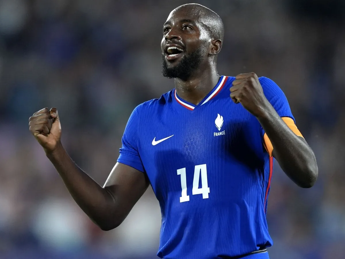 Giocatore della nazionale francese con maglia blu festeggia con i pugni chiusi dopo un’azione in campo.