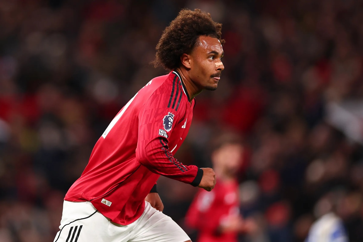 Calciatore del Manchester United con maglia rossa corre in campo durante una partita di Premier League, concentrato sull’azione di gioco.
