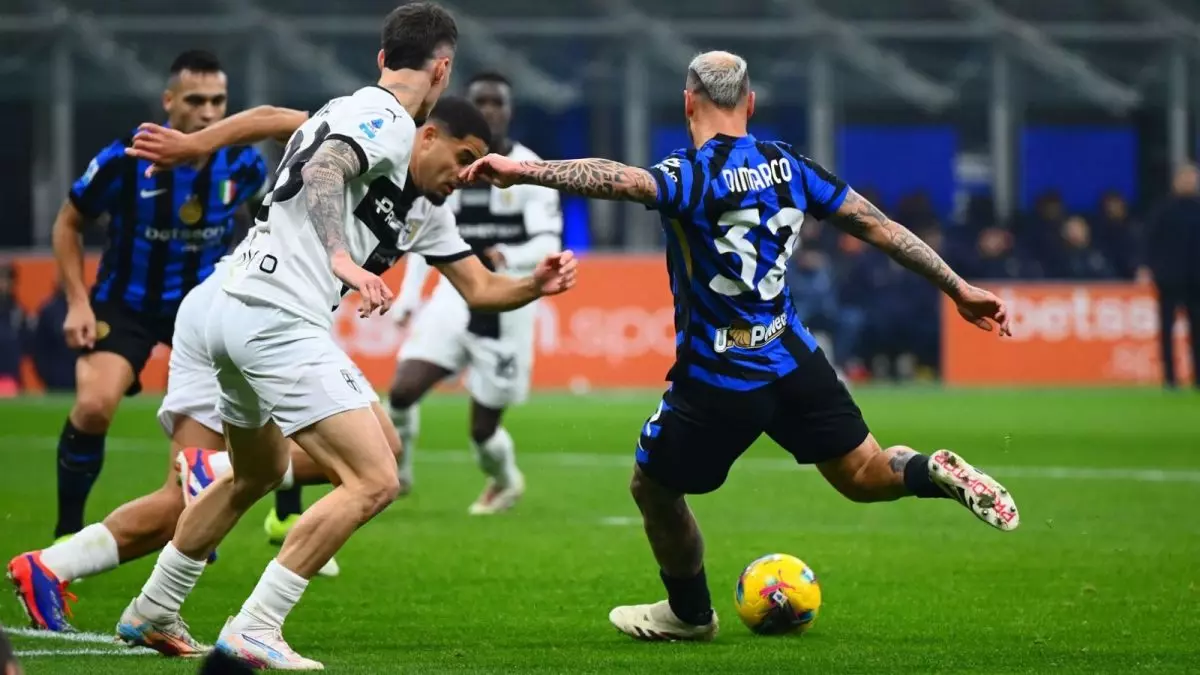 Giocatori di Parma e Inter si contendono il pallone in un’azione ravvicinata durante una partita di calcio