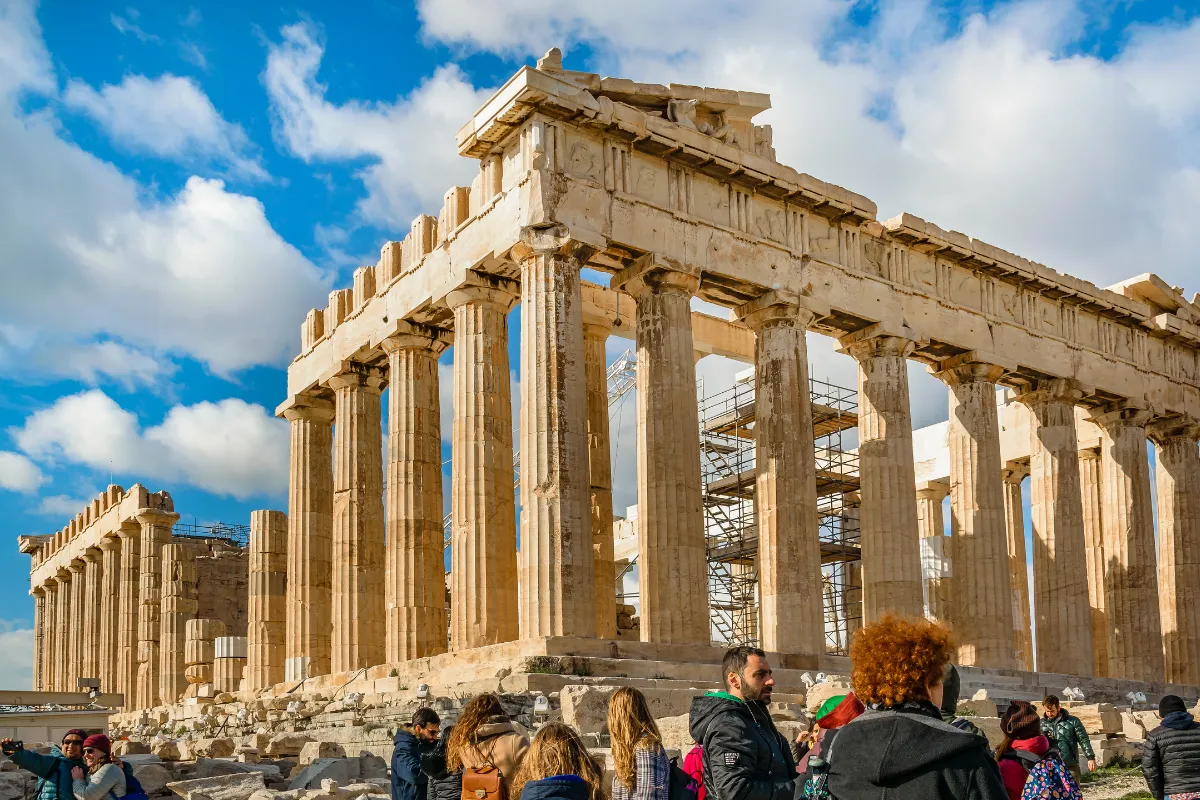 Il tempio del Partenone sull'Acropoli di Atene, con turisti che passeggiano tra le antiche colonne.