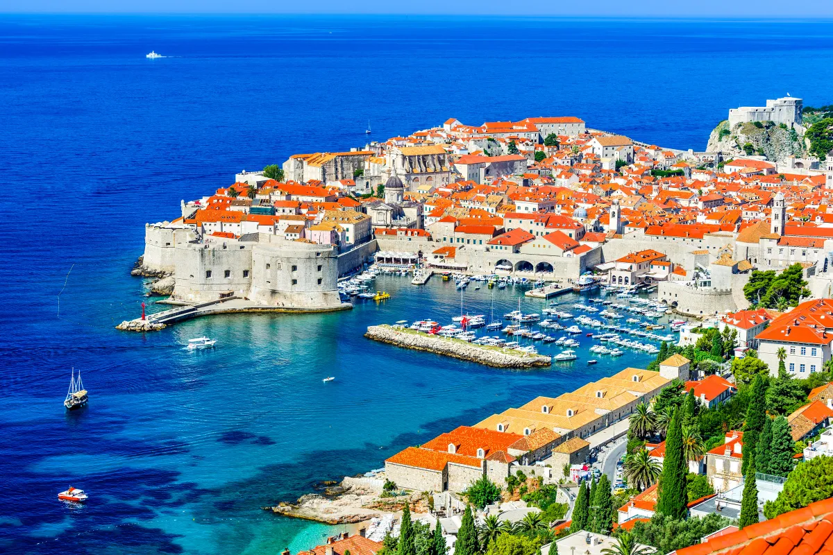 Vista aerea della città vecchia di Dubrovnik con le sue mura storiche, i tetti in terracotta e le barche sul mare Adriatico.