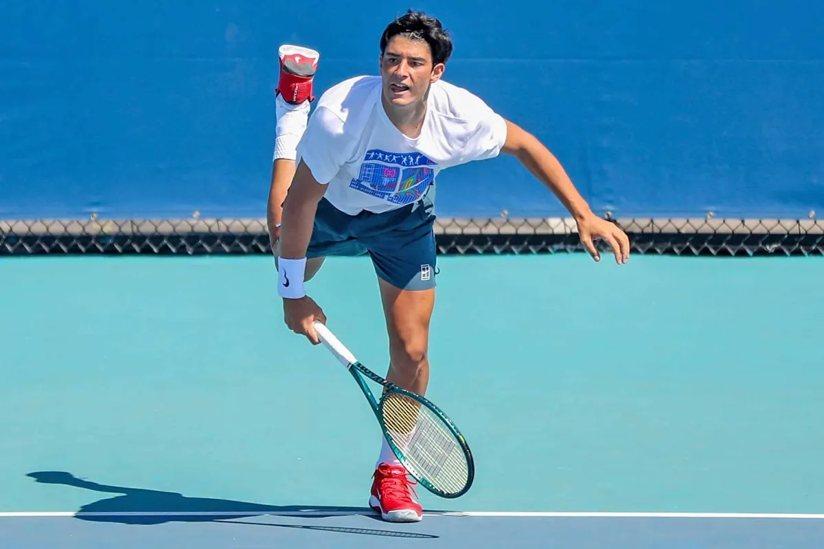 Tennista italiano esegue il servizio su un campo in cemento durante una sessione di allenamento