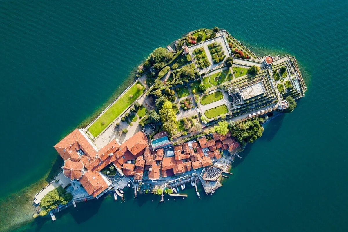 Vista aerea dell'Isola Bella con giardini terrazzati ed edifici storici circondati dalle acque del Lago Maggiore.