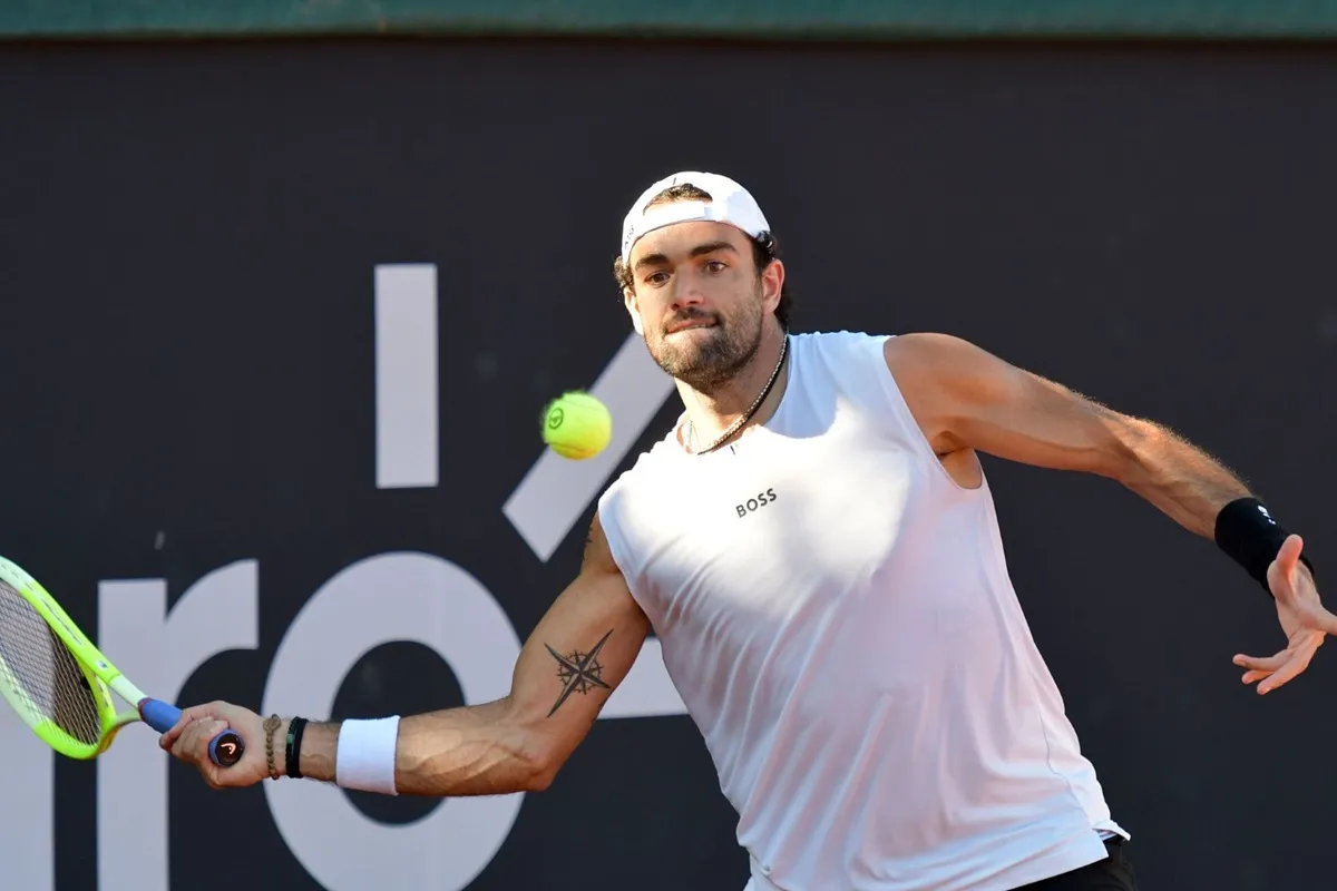 Tennista professionista colpisce una palla da tennis con un dritto durante una partita su campo all’aperto