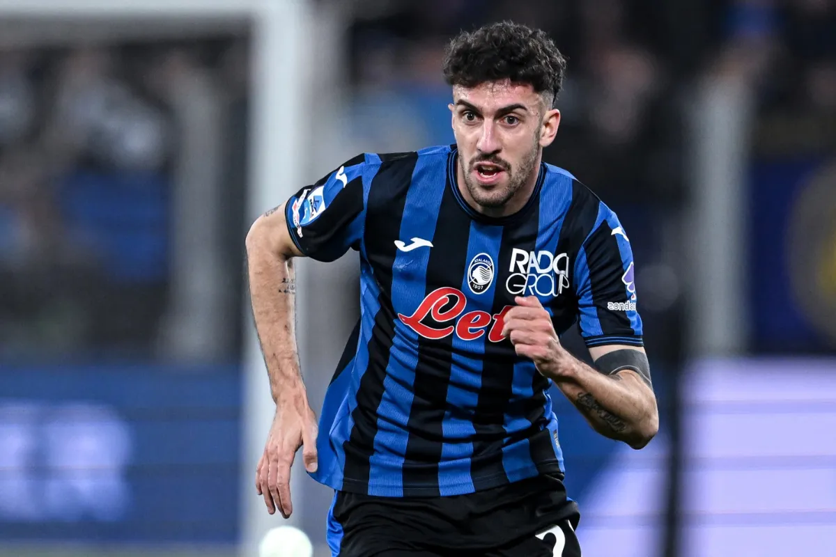 Il calciatore Matteo Ruggerie corre sul campo indossando la divisa blu e nera dell'Atalanta durante una partita.