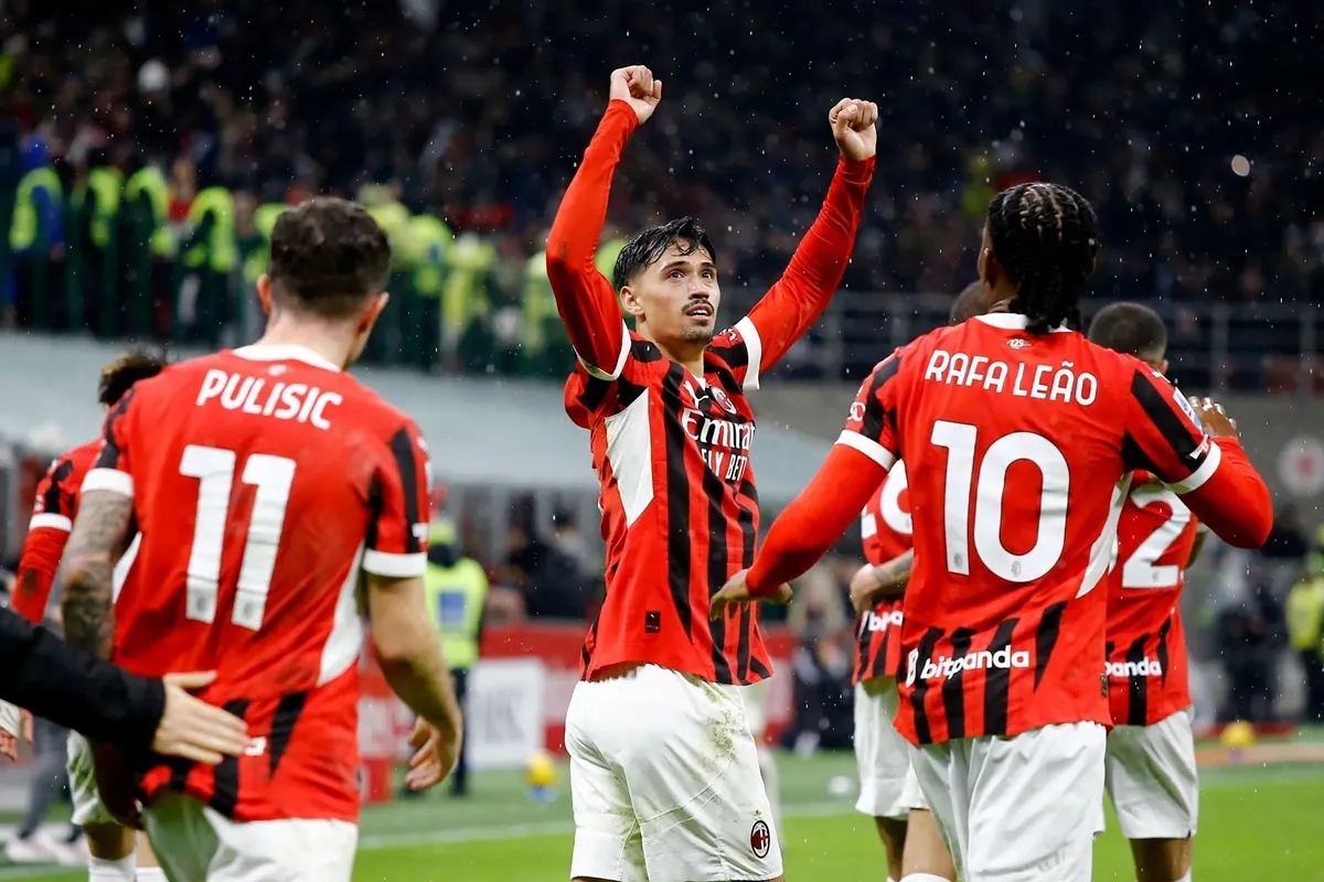 Calciatori del Milan con maglia rossonera celebrano un gol in campo durante una partita allo stadio San Siro
