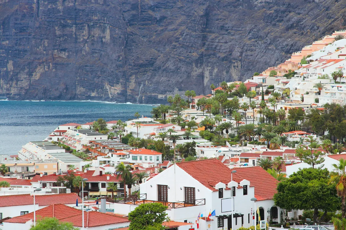 Case bianche con tetti rossi su una collina che domina il mare e le scogliere.