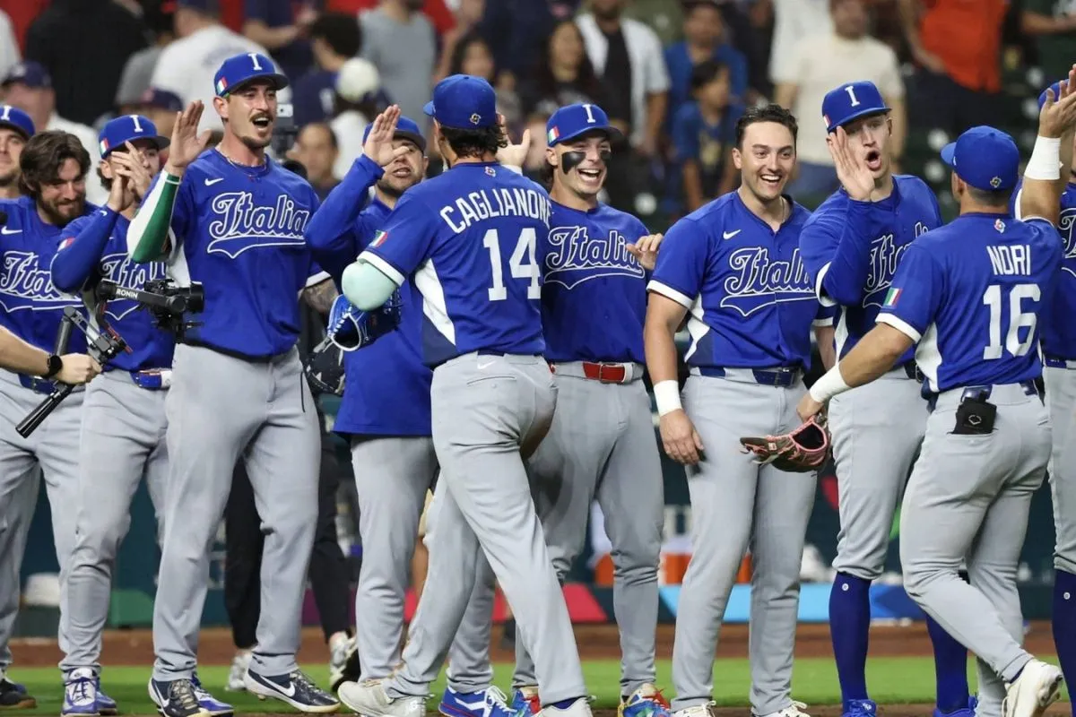 Squadra nazionale italiana di baseball che celebra con il cinque alto sul campo durante una partita.