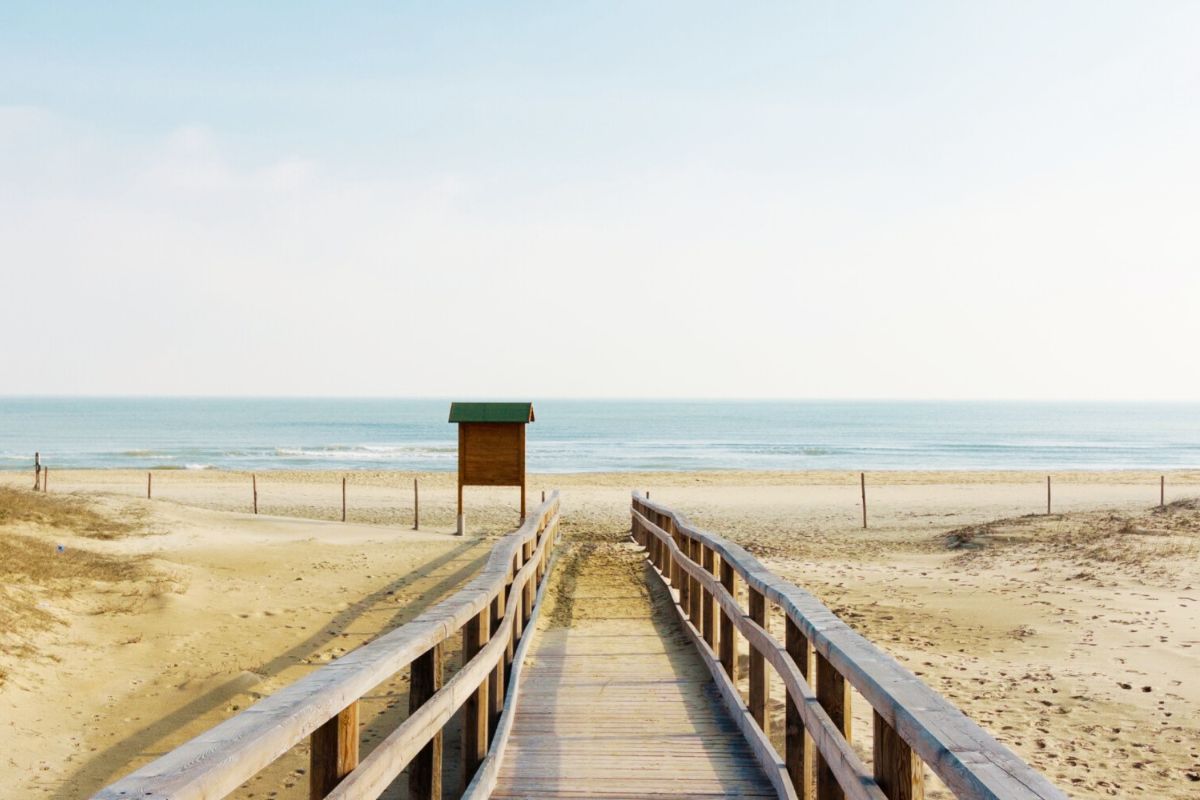 Passerella in legno che attraversa le dune e conduce alla spiaggia e al mare