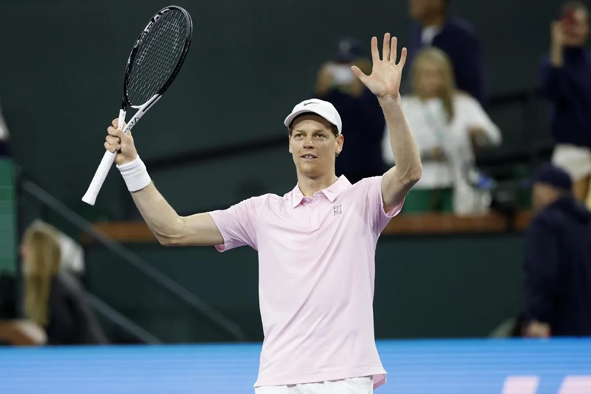 Tennista professionista saluta il pubblico con la racchetta alzata durante il torneo di Indian Wells.