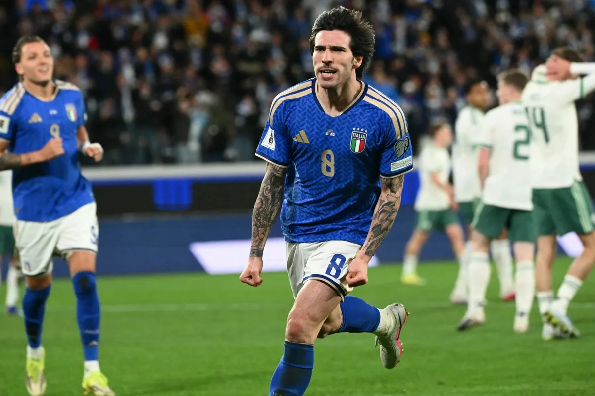 Calciatore dell’Italia con maglia blu numero 8 esulta dopo un’azione durante una partita di calcio internazionale