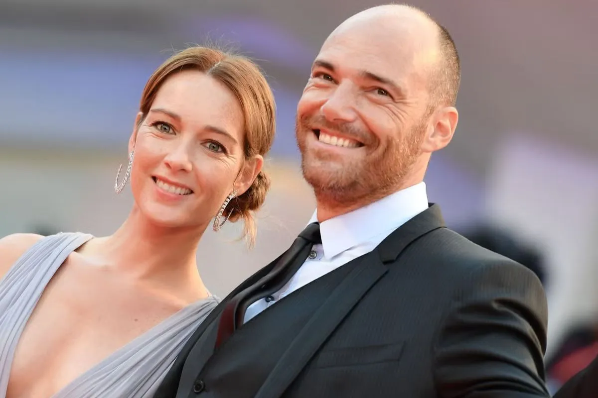 Uomo e donna eleganti sorridono insieme durante un evento formale sul red carpet