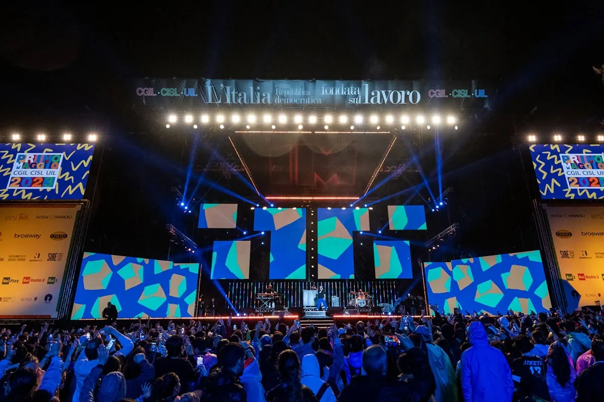 Grande folla assiste al Concerto del Primo Maggio con palco illuminato e schermi LED a Roma