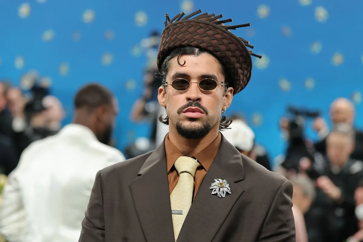 Bad Bunny indossa abito marrone con cravatta beige e cappello intrecciato durante evento sul red carpet